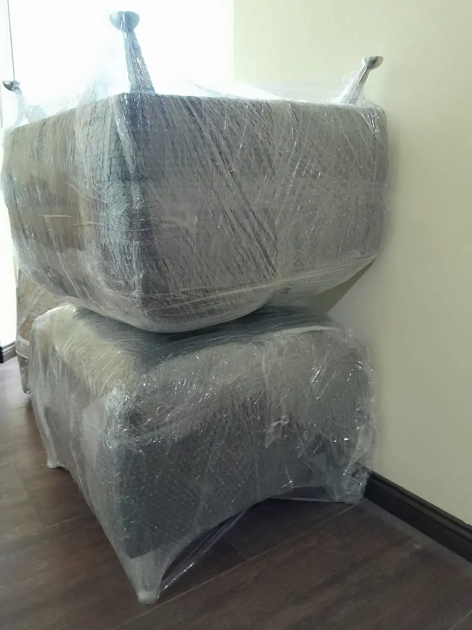 Mueble de madera tipo vajillero protegido con múltiples capas de film stretch para asegurar puertas y cajones durante el transporte.